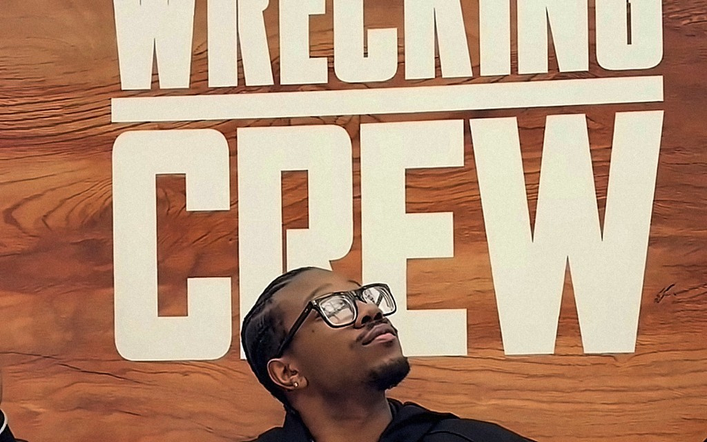 Creator in front of a Wrecking Crew poster